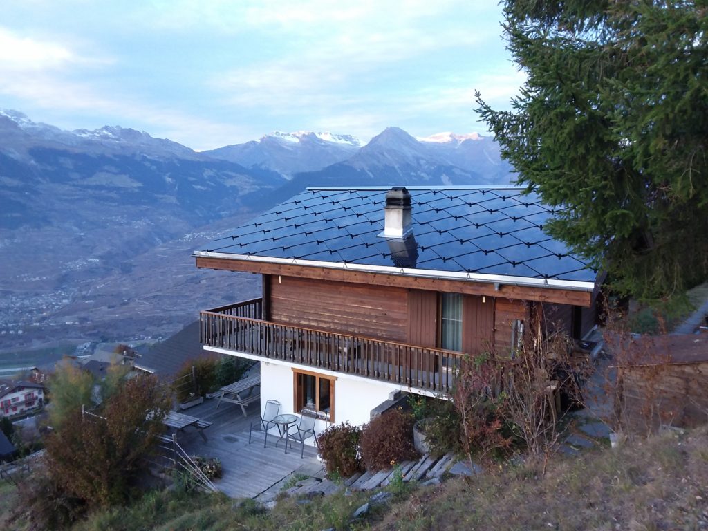 Chalet transformé du chauffage au gaz fossile vers une magnifique toiture solaire photovoltaïque et un chauffage central au bois.